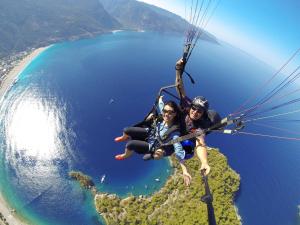 two people are flying in a parachute over the ocean at KiDRAK OTEL MONTENEGRO-1 in Faralya
