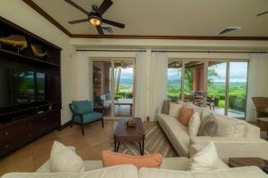 エラドゥーラにあるMontebello 2E 3 bdr Ocean View in Los Suenosのソファとテレビのあるリビングルーム
