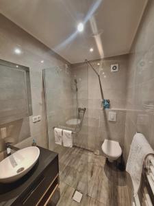 a bathroom with a shower and a sink and a toilet at Apartman Nora in Široki Brijeg