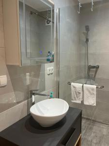 a bathroom with a white sink and a shower at Apartman Nora in Široki Brijeg