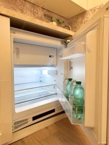 ローマにあるCasa Blaserna nel Cuore dello Shopping a Marconi e Trastevereのたくさんの緑色のガラス瓶が詰まった冷蔵庫