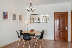 a dining room with a table and chairs and a mirror at Villa Nitho in Playa Blanca