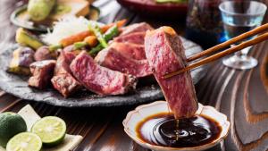 a plate of food with a piece of meat being dipped in sauce at LiVEMAX Resort Echigo Yuzawa in Yuzawa