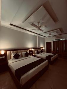 a bedroom with two beds and a ceiling at Hotel the shore by Trindra Hospitality in Rishīkesh