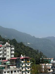 a group of buildings with mountains in the background at Hotel the shore by Trindra Hospitality in Rishīkesh +17 photos