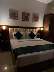 a bedroom with a large bed with two pictures on the wall at Hotel the shore by Trindra Hospitality in Rishīkesh