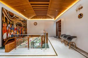 a room with a staircase with chairs and a mural at HSR Penthouse Spacious 4-BHK Apartment with Living, Lounge Area, Study Room, Terrace & Balconies in Bengaluru