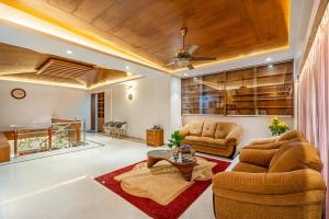 a living room with two chairs and a table at HSR Penthouse Spacious 4-BHK Apartment with Living, Lounge Area, Study Room, Terrace & Balconies in Bengaluru