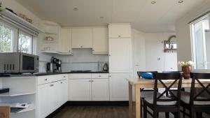 a kitchen with white cabinets and a wooden table at Park Welgelegen, bungalow 01 in Cadzand