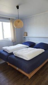 a bedroom with two beds with blue and white sheets at Park Welgelegen, bungalow 01 in Cadzand +14 photos