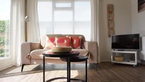 a living room with a couch and a table at Park Welgelegen, bungalow 01 in Cadzand