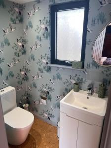 a bathroom with pink flamingos on the wall at Williams Cottage A High end little home with antique style in Tarporley +17 photos