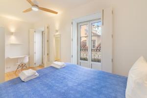 a bedroom with a blue bed with two towels on it at Alfama Fado Apartments in Bicas