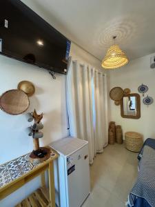 Cette chambre dispose d'un réfrigérateur et d'une télévision murale. dans l'établissement Suítes BG - Rua principal de Barra Grande, à Barra Grande