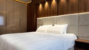 a bedroom with a large bed with white sheets at Luxury Hermes Apartement Marina View-Mall-Parking in Tangier