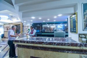 two men standing at a bar in a restaurant at Dündar Hotel in Konya