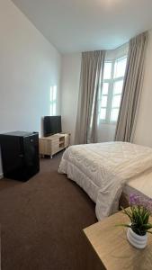 Un dormitorio con una cama y un televisor de pantalla plana. en Khalifa A Home Stay Small Room, en Sabkhah