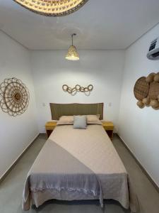 une chambre avec un grand lit dans une pièce dans l'établissement Suítes BG - Rua principal de Barra Grande, à Barra Grande