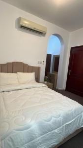 Un dormitorio con una gran cama blanca con ventana. en Khalifa A Home Stay Small Room, en Sabkhah