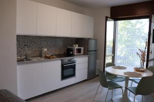 a kitchen with white cabinets and a table with chairs at Casa Rovedine in Opera