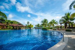a swimming pool at a resort with palm trees at Bella Vista 3F 3 bdr beach club view in Los Suenos in Herradura