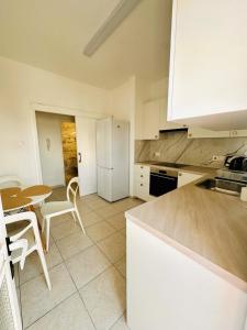 ニコシアにあるCharming 2 Bdr Nicosia Apt Free Parking & Wi-Fiのテーブルと白い冷蔵庫のあるキッチン