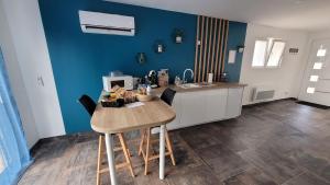 a kitchen with a wooden table and a blue wall at " Bulles et Evasion - Maison, Spa en option" in Ville-le-Marclet
