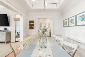 a dining room with a table with a vase of flowers at Ave 30A by Coastal Dreamin in Santa Rosa Beach