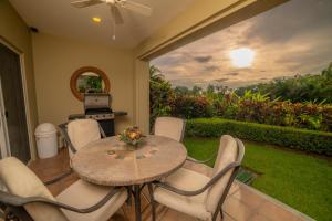 un patio con mesa y sillas y un jardín en Del Mar 4M 3 bdr Garden View in Los Suenos, en Isla Herradura