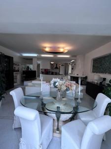 a living room with a glass table and white chairs at Villa Pina b&b in Colleferro