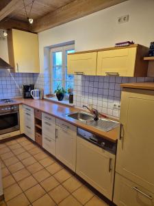 a kitchen with yellow cabinets and a sink at Ferienwohnung de Best inkl. Chiemgaukarte in Ruhpolding