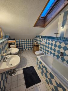 Un baño con dos lavabos, una bañera y un inodoro. en Ferienwohnung de Best, en Ruhpolding