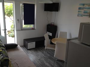 un soggiorno con tavolo, tavolo e sedie di Apartment Goreta a Trogir