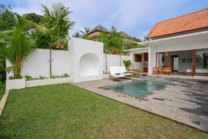 ウブドにあるThe Surana Villas Ubud with Rice Field Viewの裏庭(スイミングプール、家あり)