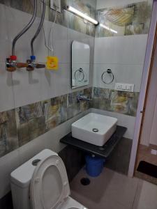 Un baño con un inodoro blanco y un lavabo. en Hotel Midway Inn, en Jagatsukh