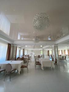 a dining room with tables and chairs and a chandelier at SV Lion 