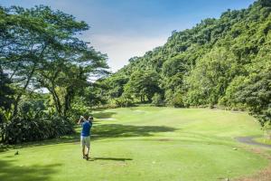un hombre parado en un campo de golf mirando un verde en Villa Angel 4 bdr Ocean View pool in Los Suenos, en Isla Herradura