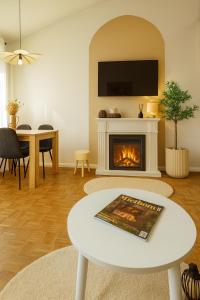 a living room with a fireplace and a table at Bayerischer Wald Hideaway, nähe Passau, Garten, Kamin, Galerie, in Waldkirchen