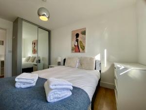 a bedroom with a bed with towels on it at Maidenehad Spacious Spectacular and Modern 3 Bedroom 2 Bathroom Penthouse 14 in Maidenhead