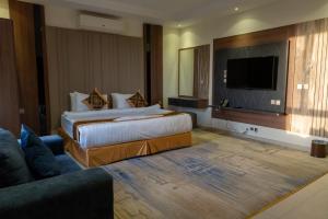 a hotel room with two beds and a flat screen tv at فندق بالم بوتيك النهضة in Jeddah