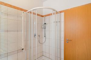une salle de bain avec une douche avec une porte vitrée dans l'établissement Ferienwohnung Theo,  25 autres photos