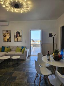 Una sala de estar con un sofá, una mesa y sillas. en Theasis Serenity Residence, 