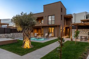 a house with a tree in the yard at Luxury Suites with private pool and BBQ by Kalles Homes & Suites in Áno Kalésia