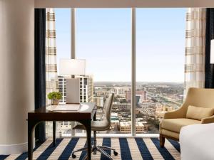 a desk and chair in a room with a large window at Fairmont Austin in Austin