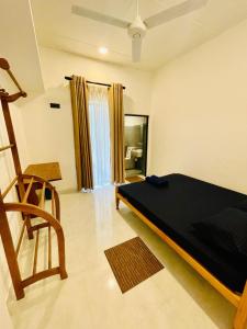 a room with a bed and a chair in it at Hotel Rays Lanka Avissawella in Avissawella