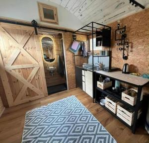 a room with a sliding barn door and a rug at Obytný vagón Bzová Běleč in Kamberk