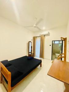 a bedroom with a black bed and a table at Hotel Rays Lanka Avissawella in Avissawella