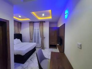 a hotel room with a bed and a table in it at Prym Hotel in Owerri +7 photos