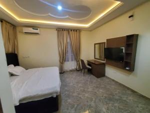 a hotel room with a bed and a television at Prym Hotel in Owerri