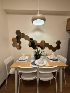 a dining room with a wooden table and chairs at 1BR Luxury Apartment The Camden Place in Manila +2 photos